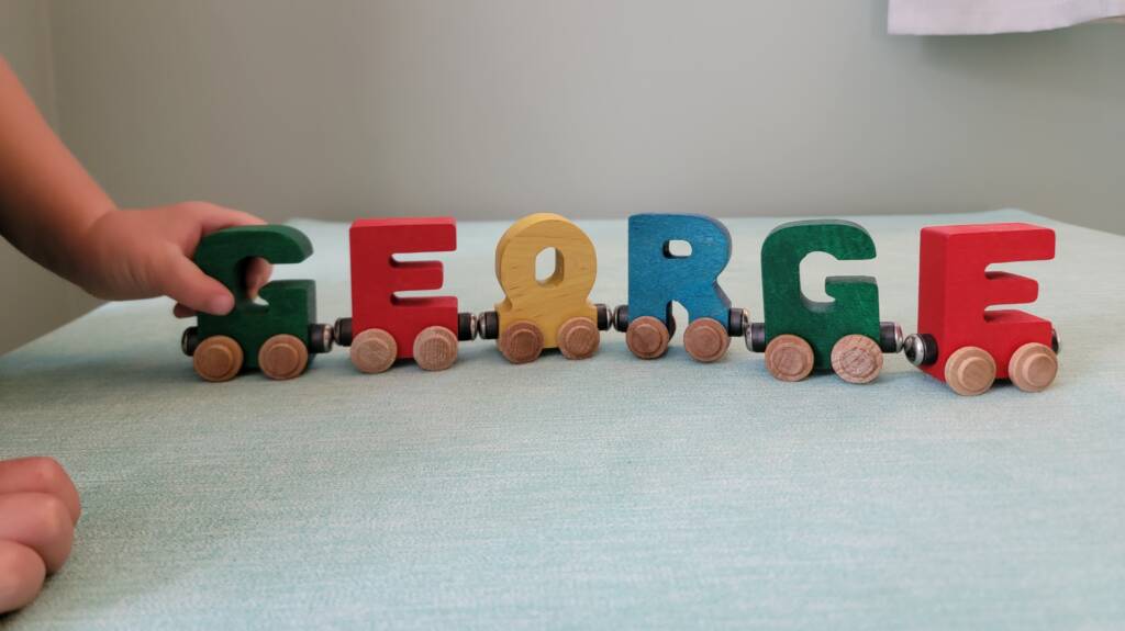 A wooden train made from the letters of the name George