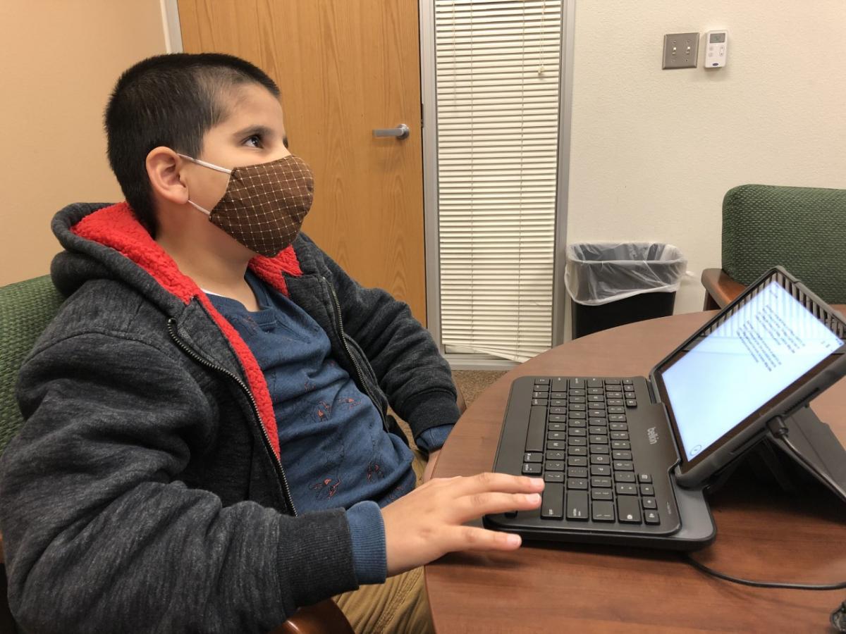 A boy writes on an iPad using an external keyboard. A boy writes on an iPad using an external keyboard.