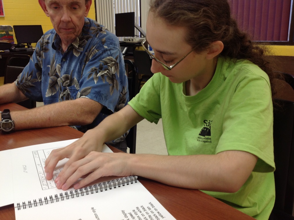 Programmer Bill Mitchell looks on she evaluates a screen shot of the iPad screen. Evaluating a screen shot of the iPad