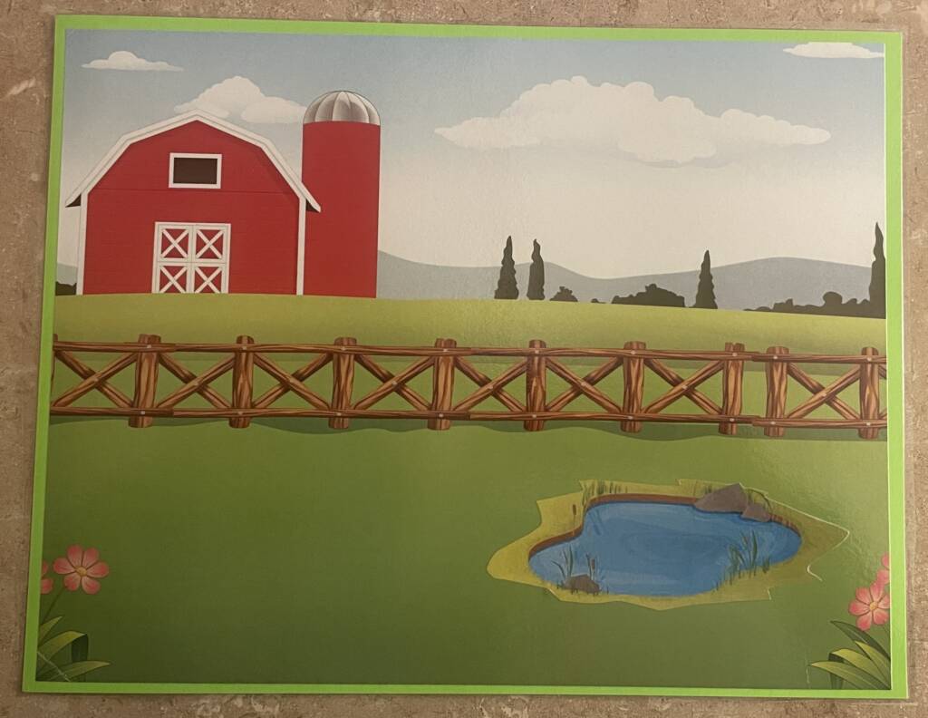 large barn in the background with a grass field, fence, and small pond in the front.