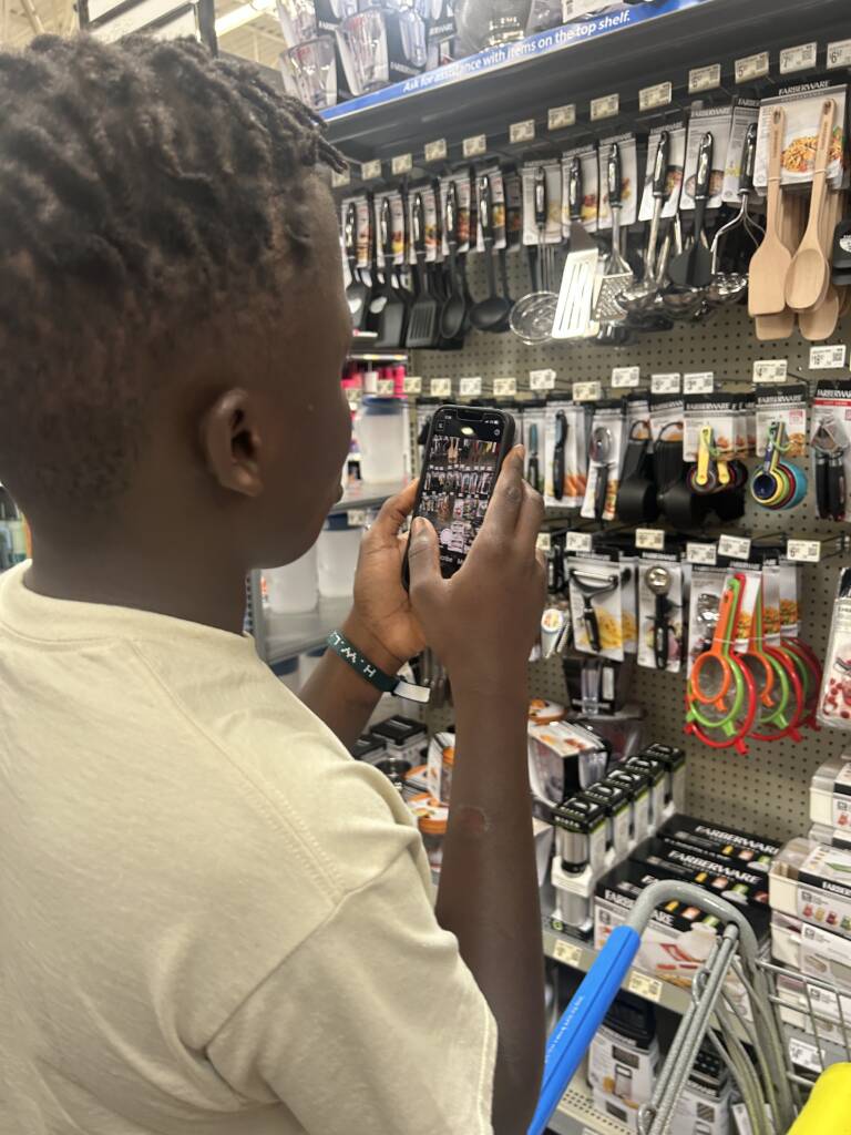 A male traveler uses Seeing AI to locate an item in a store display. 