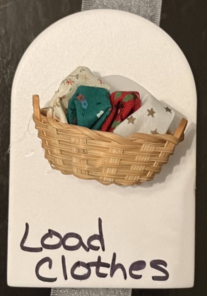 Tactile symbol for load clothes that has a small basket of clothes.