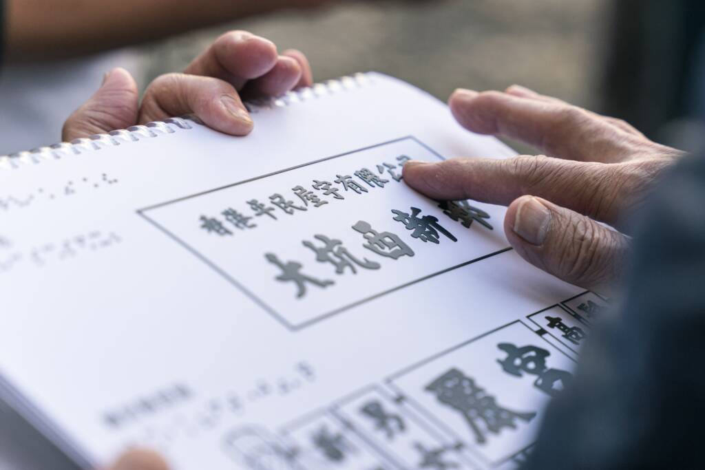 Person using finger tips to touch symbols in braille.