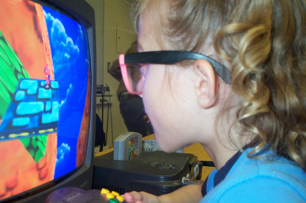 Haylee sitting a few inches from the TV monitor.