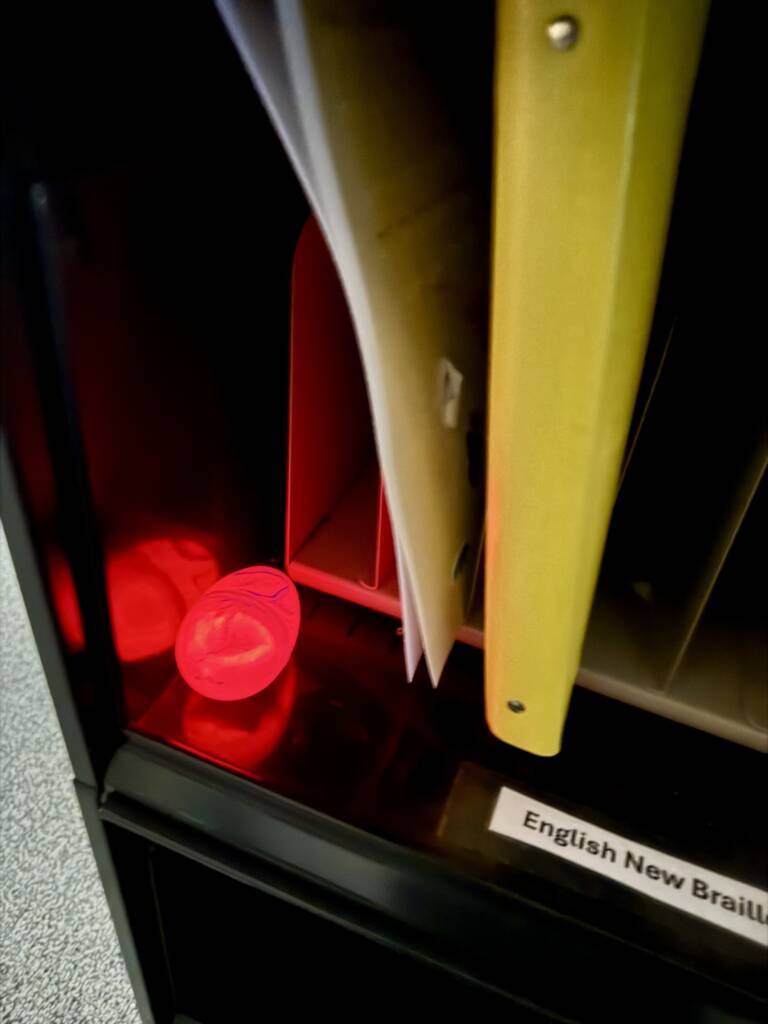Light up, red plastic egg on a shelf.