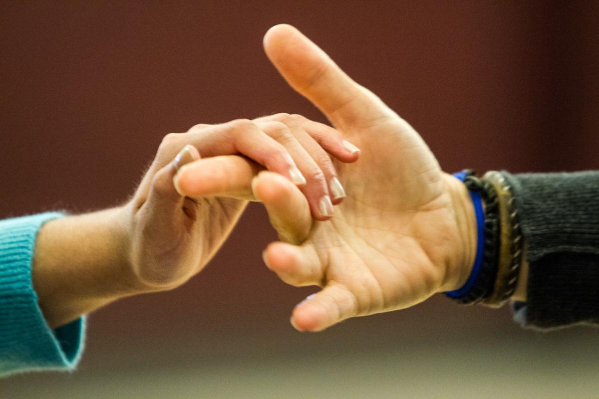 The hands of two people engaged in tactile sign