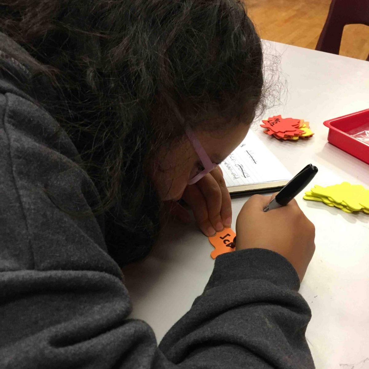 A girl writes what she is thankful for. Writing what she is thankful for