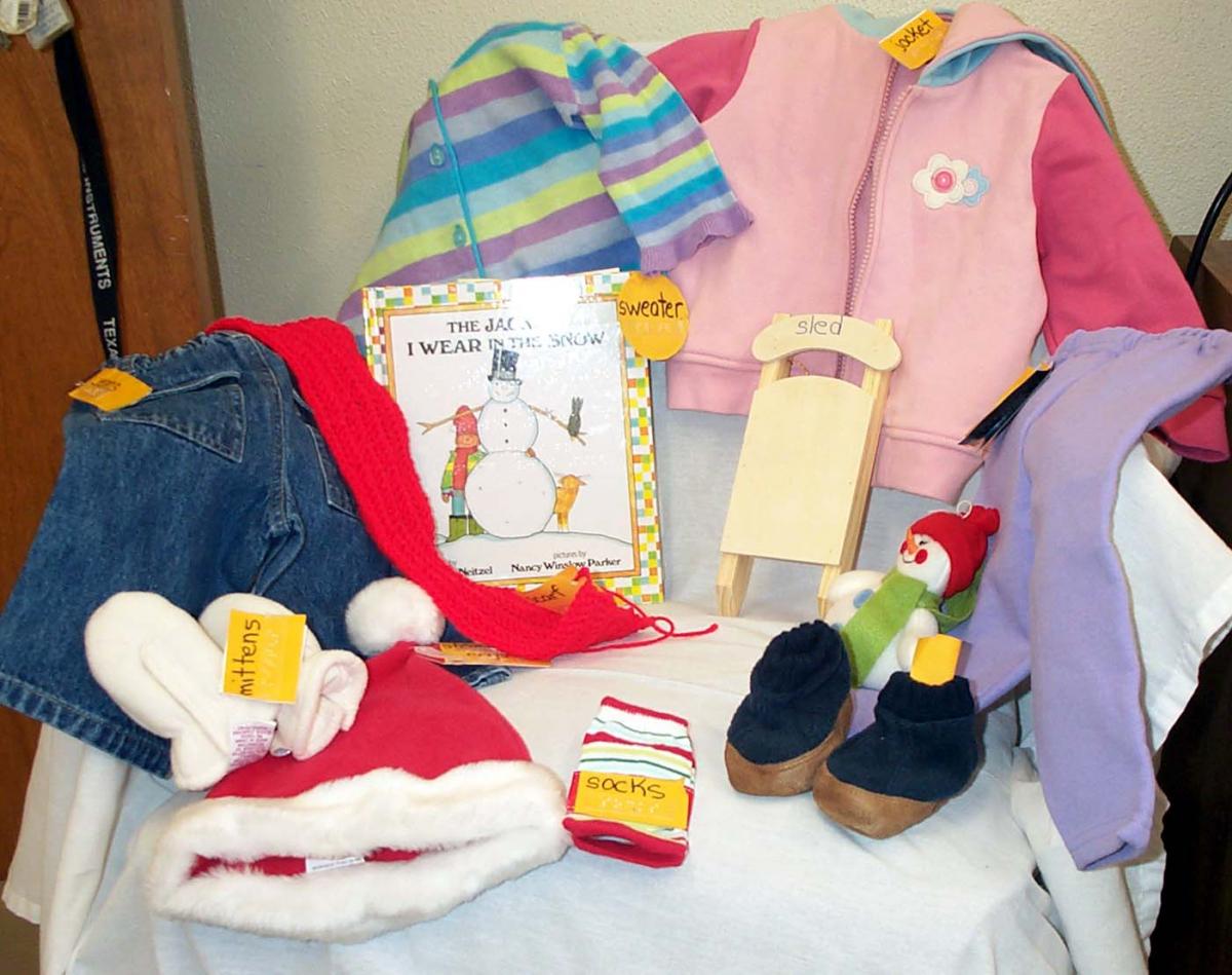 Click to enlarge story box items Book shown with a jacket, slippers, pants, small woooden sled and several other objects.