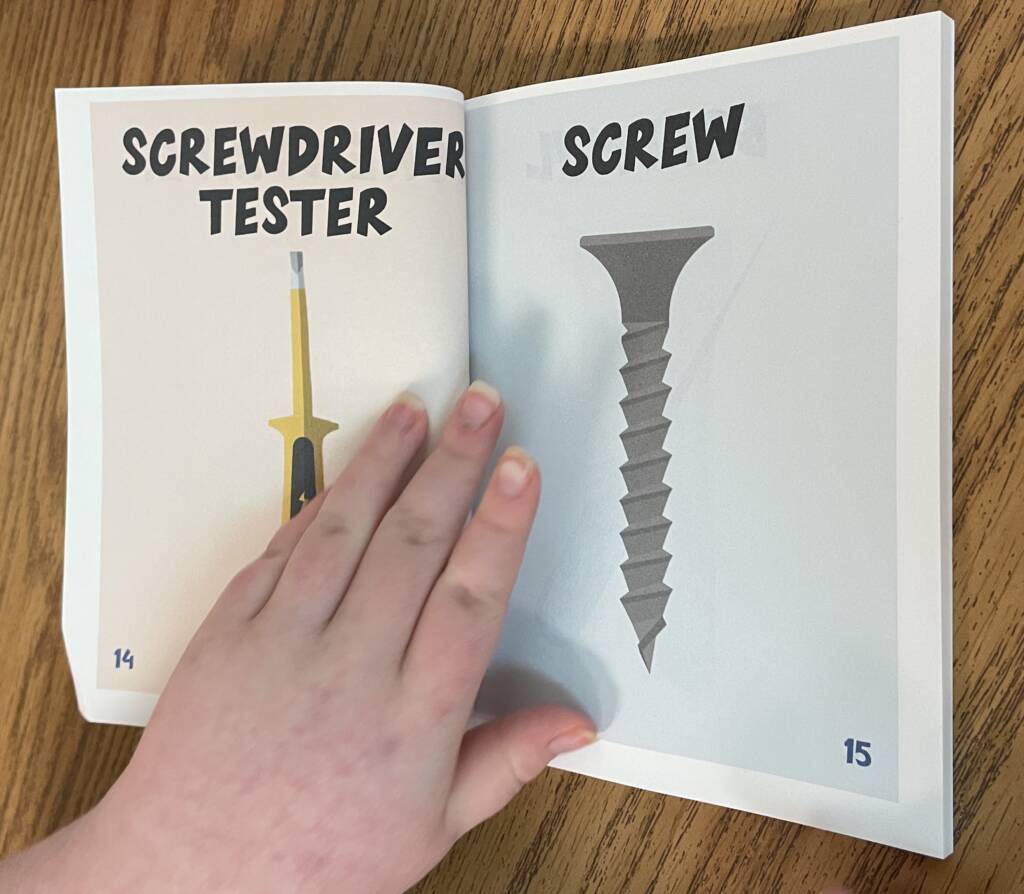 Hand on a page of the book about tools.