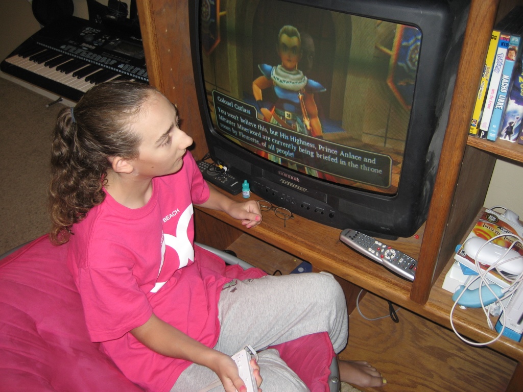 Haylee has to get very close to see the video games, but she is a whiz at playing them. Girl plays video games
