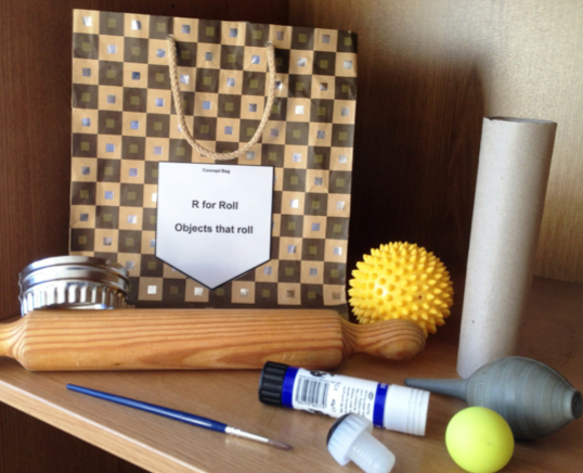 concept bag with ball, rolling pin, paper towel roll, pen, salt shaker