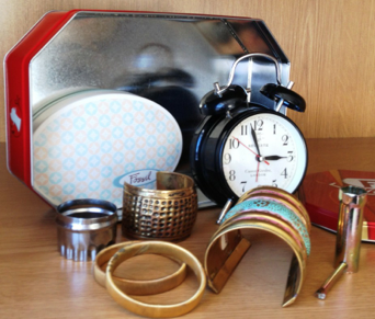 tin box of metal objects: clock, bracelets,
