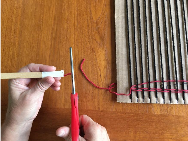 Clipping the shed stick from the first color of yarn Clipping the shed stick from the first color of yarn