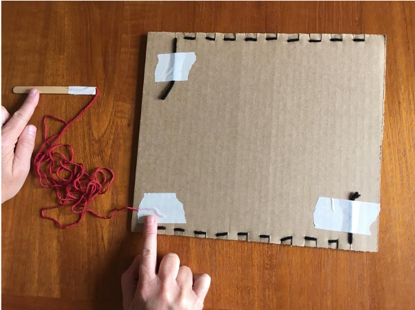 Taping yarn to back of loom Taping yarn to back of loom