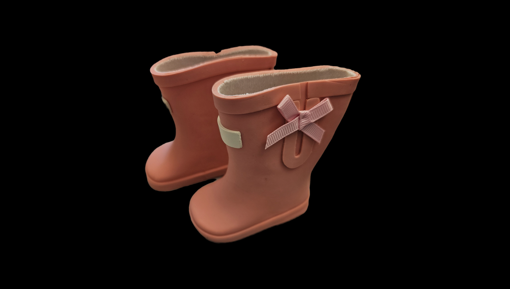 Pink rubber boots with bows on the side.