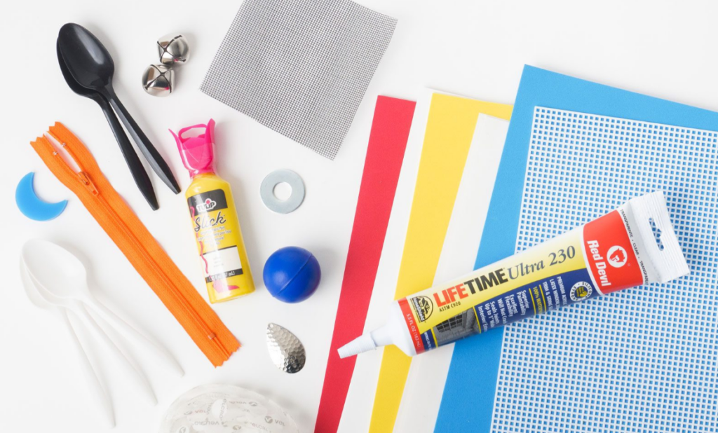 An array of materials used to make a tactile symbol using the APH tactile connections that includes a plastic spoon.