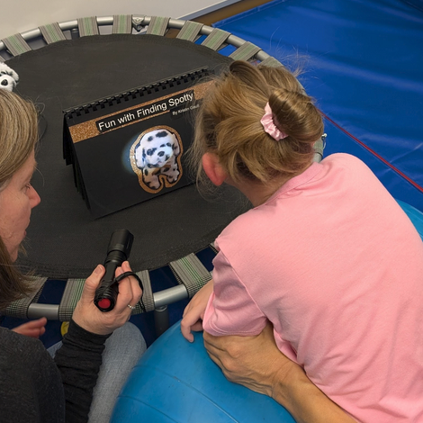 Student and teacher looking as a photo of Spotty the dog.